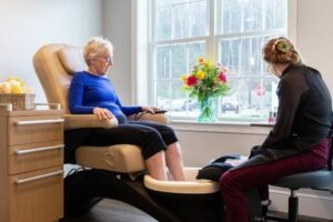 A woman sitting in a chair getting a pedicure