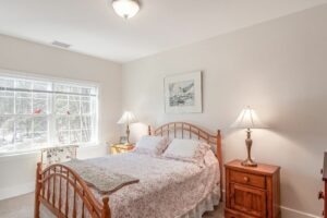 Apartment interior of a bedroom with queen sized bed and nightstands