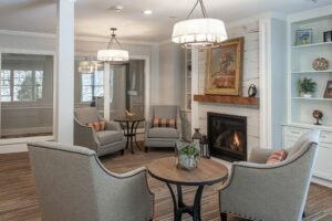 Common area interior with lounge chairs around a fireplace