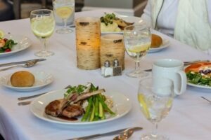 Dining room table close up with plates of delicious food with candle centerpiece