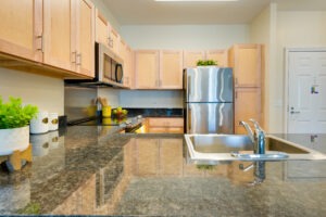 Apartment kitchen with stone countertops and wooden cabinets