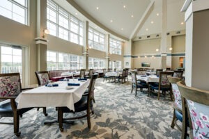 Dining room interior with several set tables and a large wall of windows