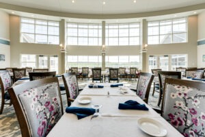 Dining room interior with several set tables and a large wall of windows