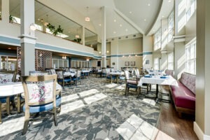 Dining room interior with several set tables and a large wall of windows