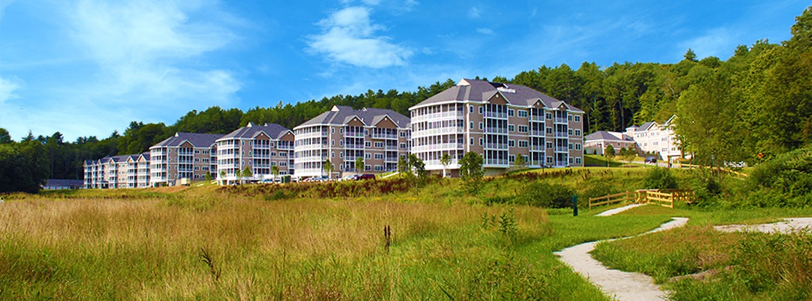 Covenant Senior Living of Keene building next to a field and outdoor walking path