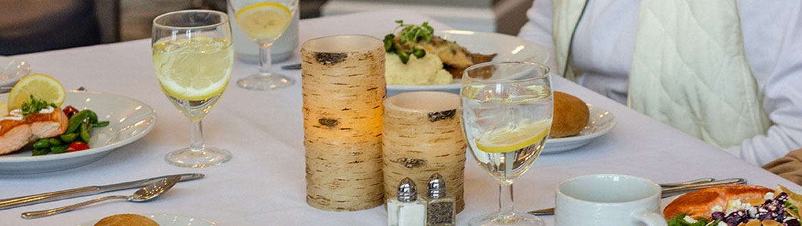 close up of a dinning table with candles and food